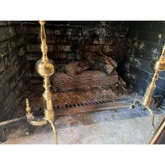 an old fireplace with two candles and a bed in the middle, surrounded by brick walls