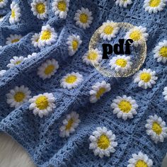 a blue crocheted blanket with yellow and white daisies on it that says pdf