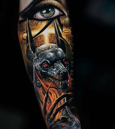 an eye and demon tattoo on the arm