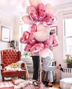 an image of balloons in the living room with pink and white decorations on top of them