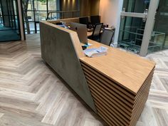 an office with wood flooring and desks in the center, along with glass doors