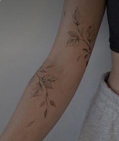 a woman's arm with leaves on it