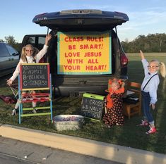 two children standing in the back of a van with a sign saying class rules be smart love jesus with all your heart