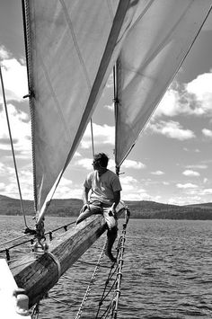 a man sitting on the end of a sail boat