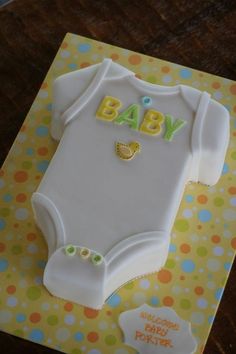 a cake shaped like a baby's bodysuit on top of a table