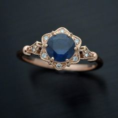 an oval shaped blue sapphire and diamond ring on a black surface with white diamonds around it