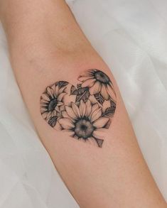 a heart shaped tattoo with sunflowers on the left side of the arm,