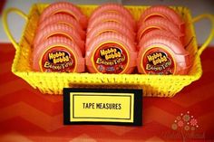 a yellow basket filled with pink donuts sitting on top of a red table cloth