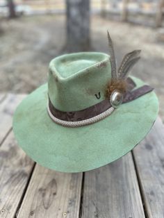 Rustic Felt Hat For Rodeo With Flat Crown, Rustic Flat Crown Felt Hat For Rodeo, Green Wide Brim Western Hat, Custom Fedora For Kentucky Derby And Ranch Events, Custom Fedora For Ranch And Kentucky Derby, Artisan Fedora For Kentucky Derby And Rodeo, Green Western Style Hat Band For Festivals, Western Green Hat Band For Festivals, Green Country Style Hat For Rodeo