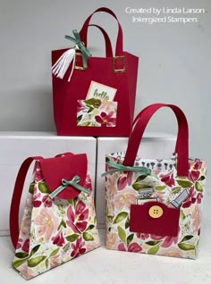 three bags with flowers on them sitting next to each other in front of a box