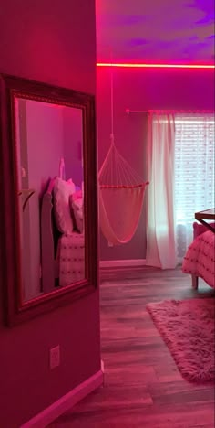 a pink bedroom with hammock hanging from the ceiling