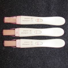 three white toothbrushes sitting next to each other on a black carpeted floor