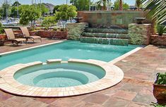 an outdoor swimming pool with a waterfall and lounge chairs around the edge, surrounded by palm trees