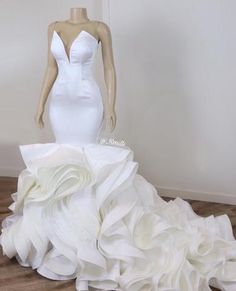 a white wedding dress on display in front of a mannequin's head