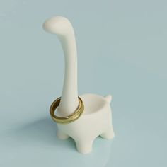 a white ceramic animal with a gold ring on it's nose and its tail