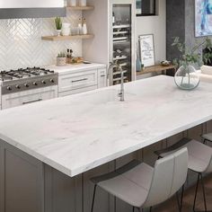 a large kitchen with an island counter top and white appliances in the middle of it