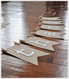 some paper signs that are sitting on the wooden floor in front of each other with letters cut out from them