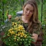 a woman holding a potted plant with yellow flowers