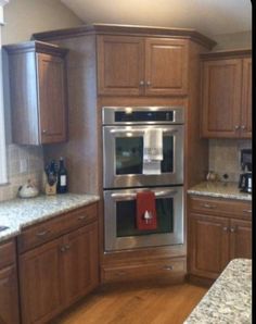 a kitchen with wooden cabinets and granite counter tops, stainless steel appliances and an oven