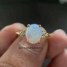 𝐌𝐚𝐢𝐧 𝐒𝐭𝐨𝐧𝐞 𝐃𝐞𝐭𝐚𝐢𝐥𝐬 *Type: Opal *Cut: Oval *Colour: FG *Clarity: VVS1 *Weight: 1.80 Ct (approx) 𝐒𝐢𝐝𝐞 𝐒𝐭𝐨𝐧𝐞 𝐃𝐞𝐭𝐚𝐢𝐥𝐬 *Type: Cubic Zirconia *Shape: Round *Colour: FG *Clarity: VVS1 *Weight: 0.20 Ct (approx) 𝐑𝐢𝐧𝐠 𝐃𝐞𝐭𝐚𝐢𝐥𝐬 *Metal Purity: Solid Gold (10k / 14k / 18k), 925 Sterling Silver *Metal Tone: White / Rose / Yellow *Stamp / Hallmarked: Yes Customization *Diamond: Natural Diamond / Moissanite / CVD -Lab Grown / Cubic Zirconia 𝐑𝐮𝐬𝐡 𝐎𝐫𝐝𝐞𝐫 *Our stan Pearl And Opal Engagement Ring, Gold Opal Birthstone Ring For Anniversary, White 14k Gold Crystal Ring, Yellow Gold Opal Diamond Ring, Yellow Gold Opal Ring With Diamond Center Stone, Gold Round Cut Opal Ring, White Gold Opal Jewelry With Center Stone, Opal Promise Ring With Center Stone, Yellow Gold Opal Ring With Diamond For Anniversary