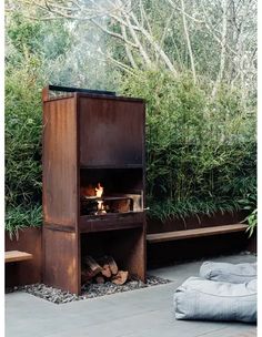 an outdoor fireplace in the middle of a garden