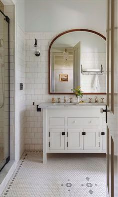 a bathroom with a sink, mirror and shower stall in it's own area