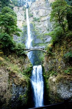 a large waterfall with a bridge over it