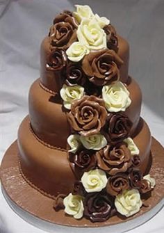 three tiered chocolate cake with white and brown flowers