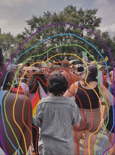 a group of people standing next to each other in front of an arch made out of colored streamers