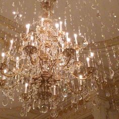 a chandelier hanging from the ceiling in a room with many lights on it