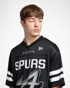 a young man wearing a black jersey with the number four on it, standing in front of a white background