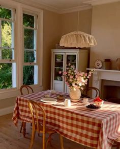 a dining room with a table and chairs in front of a window that looks out onto the woods