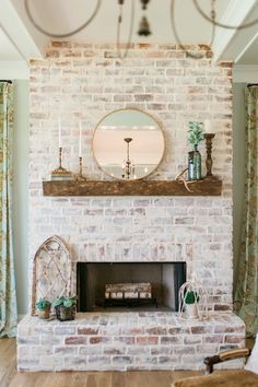 a living room with a brick fireplace and mirror