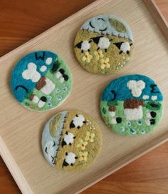 three decorated buttons sitting on top of a wooden tray