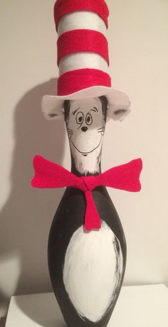 the cat in the hat is sitting on top of a vase