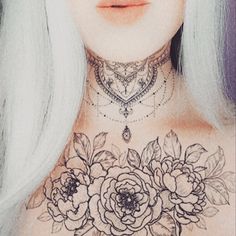 a woman with white hair and tattoos on her chest