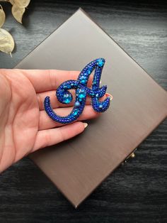 a blue brooch sitting on top of a wooden table