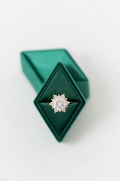 an engagement ring in a green box