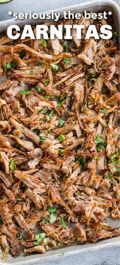 shredded meat in a casserole dish with parsley and cilantro on the side