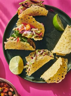 tortillas and salsa on a black plate with lime wedges