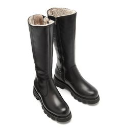 Knee high shearling-lined leather boot featuring a round toe with stitching details, an elevated profile in the front, a sturdy lug sole, and a functional interior side zipper. Functional Interior, Warm Winter Boots, Fall Booties, Lug Sole Boots, High Leather Boots, Bootie Sandals, Shearling Boots, Strappy Wedges, Loafer Sneakers