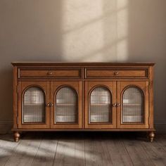 an old wooden cabinet with glass doors on the side in front of a white wall