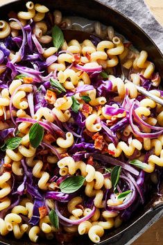 a skillet filled with pasta and vegetables