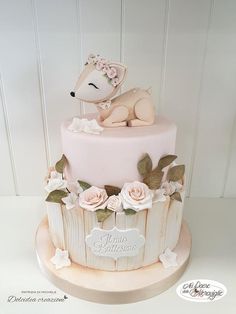 a pink cake with white flowers and a dog on it's top is shown