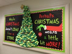 a christmas tree made out of books is hanging on the wall next to a bulletin board