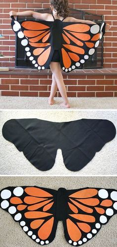 a woman is standing in front of a brick wall with an orange and black butterfly wings