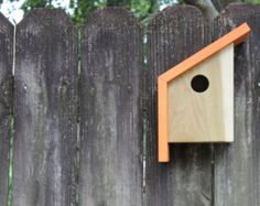 a bird house on the side of a wooden fence