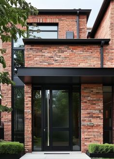 the front entrance to a brick house with glass doors