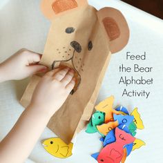 a child's hand is holding a paper bag with an animal face on it