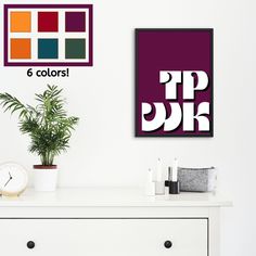 a white dresser topped with a potted plant next to a wall mounted art piece